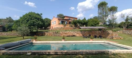 - une piscine dans une cour avec une maison en arrière-plan dans l'établissement Belle Villa à la campagne avec piscine, à Brue-Auriac