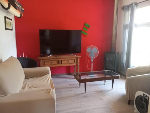 sala de estar con TV de pantalla plana y sofá en Colibrí, en Piriápolis