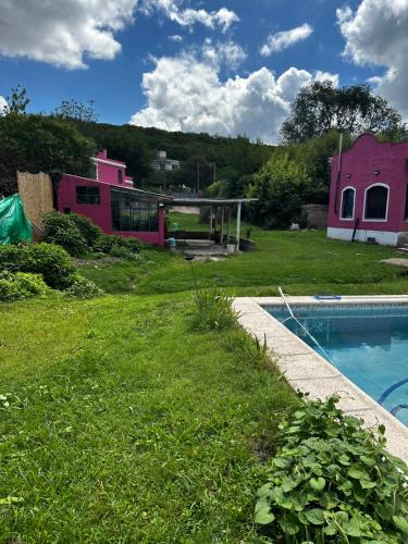 un patio con piscina y una casa rosa en Rosadita loft en Río Ceballos
