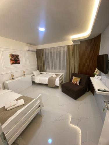 a room with two beds and a couch and a desk at Villa Jelena in Negotino