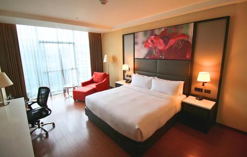 a hotel room with a bed and a red chair at Hilton Garden Inn Lima Surco in Lima
