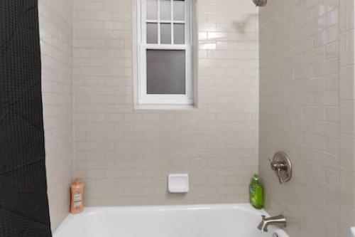 a bathroom with a white tub and a window at Affordable 1-BR by DMC Detroit in Detroit
