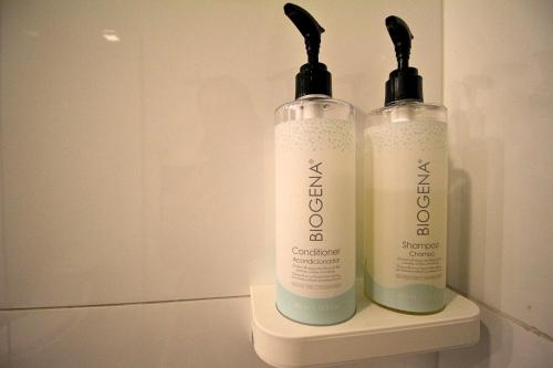 two bottles of shampoo sitting on a shelf in a bathroom at Hilton Garden Inn Lima Surco in Lima