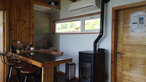 eine Küche mit einer Theke und einem Herd in einem Zimmer in der Unterkunft Cabañas Patagonia Indómita in Coihaique