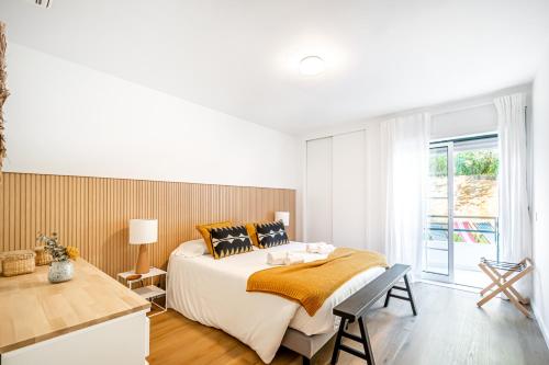 - une chambre blanche avec un grand lit et une fenêtre dans l'établissement BeGuest Falesia Beach & Garden, à Albufeira