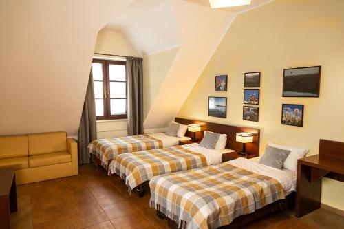 a hotel room with two beds and a couch at Kikity Siedlisko z lądowiskiem in Kolno
