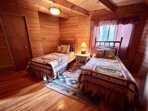 une chambre avec deux lits dans une cabane en rondins dans l'établissement Lake Michigan Cabin w/Hot Tub & Stunning Views, à Manistique