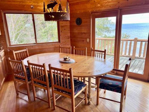 una sala da pranzo con tavolo e sedie in legno di Lake Michigan Cabin w/Hot Tub & Stunning Views a Manistique