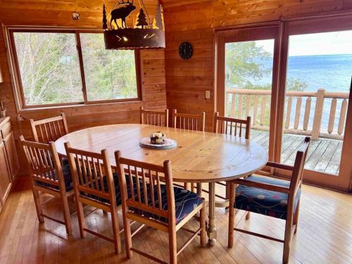 une salle à manger avec une table et des chaises en bois dans l'établissement Lake Michigan Cabin w/Hot Tub & Stunning Views, à Manistique