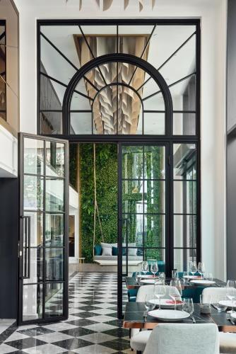a dining room with tables and chairs and a large window at La Fleur Boutique Hotel in Tivat