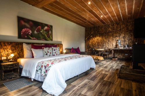 a bedroom with a large bed and a desk at Hotel Termales del Ruiz in Manizales