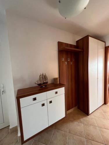 a room with a white chest of drawers and a closet at Panoráma Gold Wellness Apartman in Siófok
