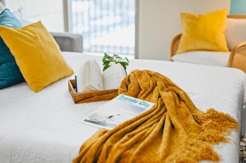 a bed with a blanket and books on it at NEW Shoreline 401 2BR Condo Near Downtown and Bay in Traverse City