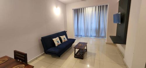 a living room with a blue couch and a window at 508 SD Zanita Heights in Vasco Da Gama