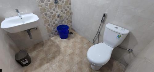 a bathroom with a white toilet and a sink at SD Zanita Heights Sea Facing Serviced Apartments in Vasco Da Gama