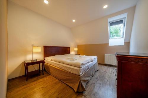 a bedroom with a large bed and a window at Villa Mandát 