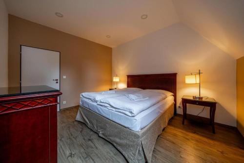 een slaapkamer met een bed en een flatscreen-tv bij Villa Mandát 