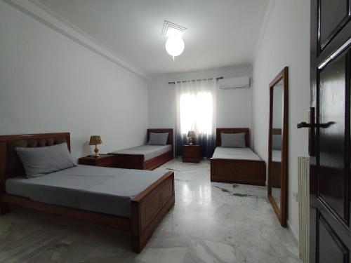 a bedroom with two beds and a window at Appartement à louer à Tlemcen in Tlemcen
