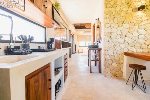eine große Küche mit einer Spüle und einer Theke in der Unterkunft Casa de Piedra - Departamentos en Bacalar in Bacalar