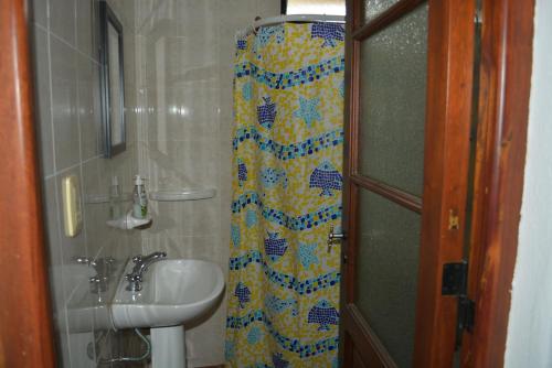 baño con lavabo y cortina de ducha en Cabaña El Canal en Villa Carlos Paz