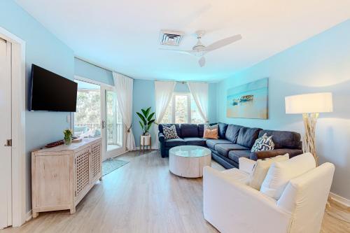 a living room with a couch and a tv at Port O' Call G-303 in Isle of Palms