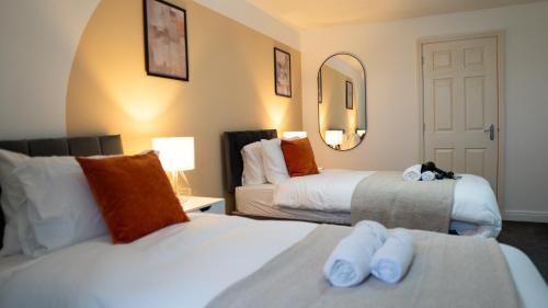Pokój hotelowy z 2 łóżkami i lustrem w obiekcie Luxurious Contractor/Family 6 Bedroom House w mieście Shenley Church End