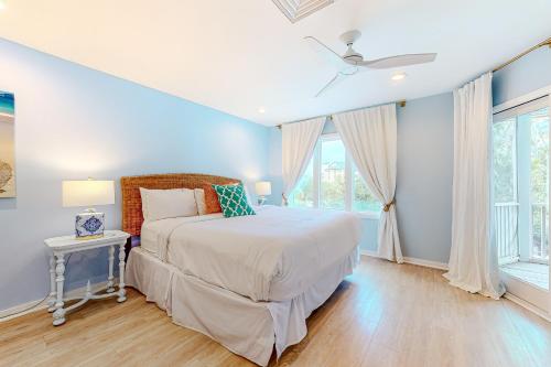 a blue bedroom with a bed and a window at Port O' Call G-303 in Isle of Palms
