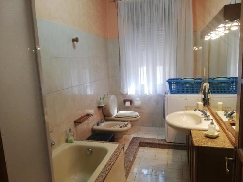 ein Badezimmer mit 2 WCs, einer Badewanne und einem Waschbecken in der Unterkunft casa Giusy in Tortorici