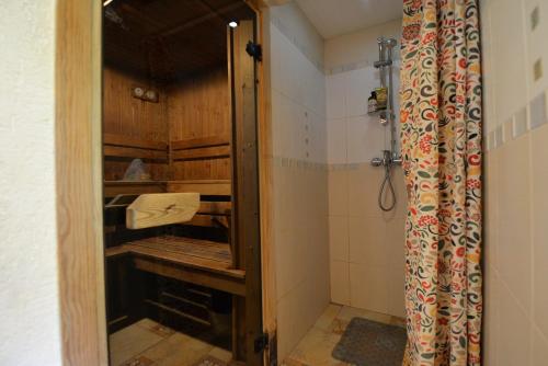 y baño con ducha y puerta de cristal. en Medaus pirtelė, en Trakai