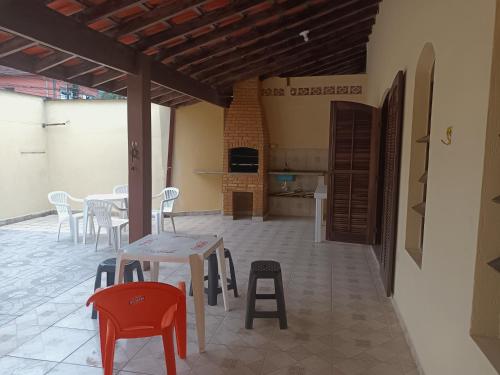 a patio with a table and chairs and a kitchen at Casa grande com churrasqueira - Centro Ubatuba in Ubatuba