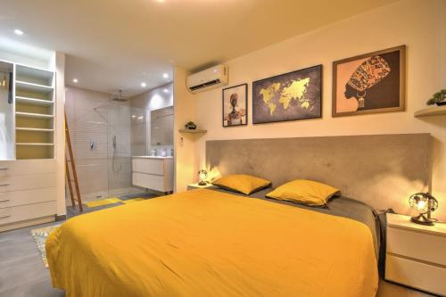 una camera con un grande letto giallo e una doccia di Appartement Canelle a Marigot