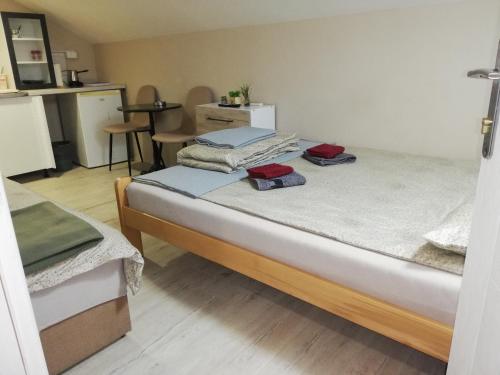 a small room with two beds and a table at Blue Carpet Rooms in Niš