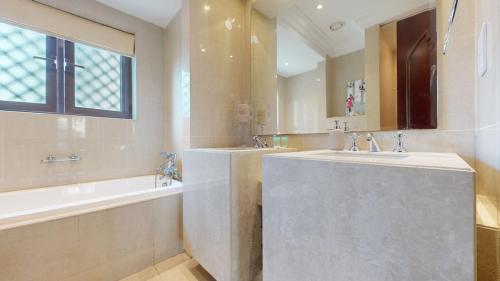 un ampio bagno con due lavandini, una vasca e un tubermott di Al Tajer - Vacationer a Dubai