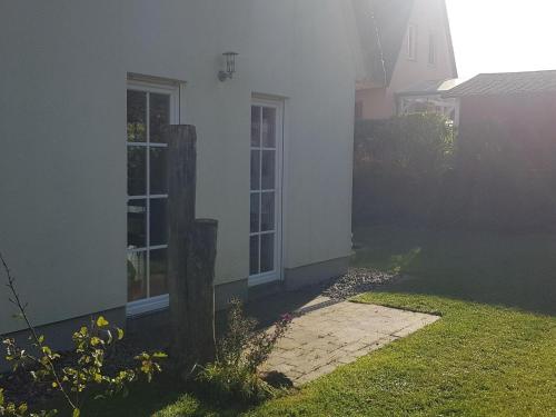 a white house with a window and a yard at Ferienhaus in Wohlenberg nahe der Ostsee in Wohlenberg