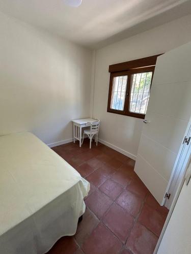 a bedroom with a bed and a table and a window at Villa Arriba in Periana