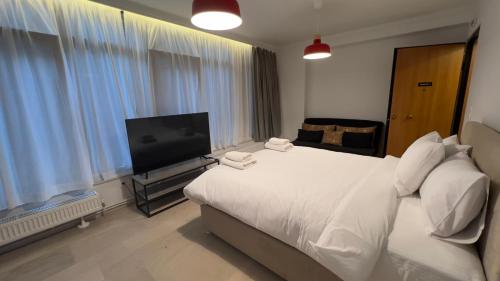 a bedroom with a white bed and a flat screen tv at Tsakalof 10 View Central Apartment by SuperHost Hub in Athens