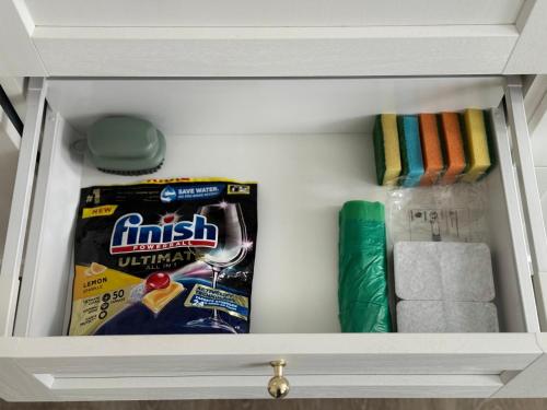 a drawer with a box of snacks and towels at Apartamentai Jums in Telšiai