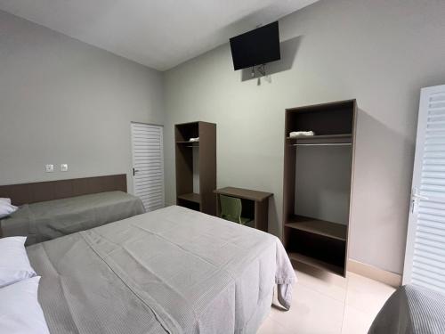 um quarto com duas camas e uma televisão na parede em Hotel Xangrilá em Salinas
