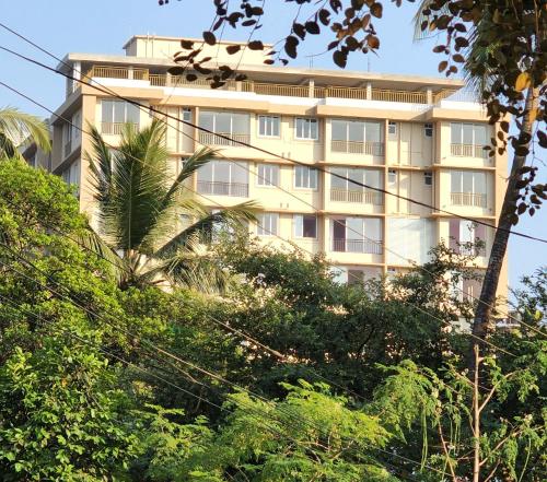 a tall building with trees in front of it at SD Zanita Heights Sea Facing Serviced Apartments in Vasco Da Gama
