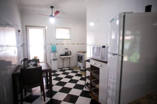 uma cozinha com piso em xadrez preto e branco em Casa em Itaipuaçu na Praça do Ferrerinha. em Maricá