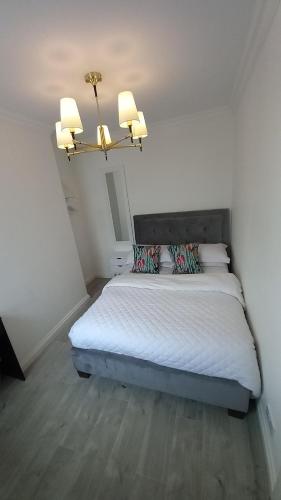 a bedroom with a bed and a chandelier at Home Away From Home,, in Kent