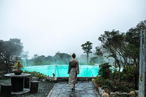 a person standing in front of a swimming pool at Hotel Termales del Ruiz in Manizales