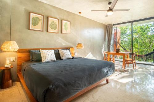 een slaapkamer met een bed en een groot raam bij Original studios by Casago in Tulum