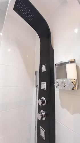 une salle de bains pourvue d'une douche avec une poignée noire. dans l'établissement Home Away From Home,,, à Kent