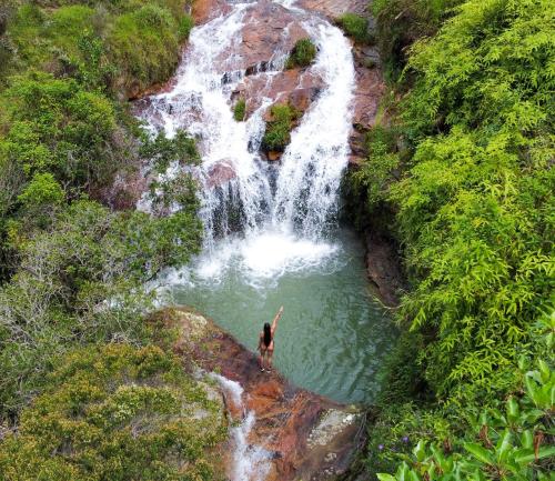 a person standing in a pool of water in front of a waterfall at Finca Ecoturistica Xtremly 