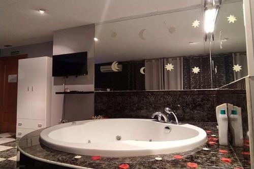 a bath tub in a bathroom with a sink at Hostal Happystay in Valencia