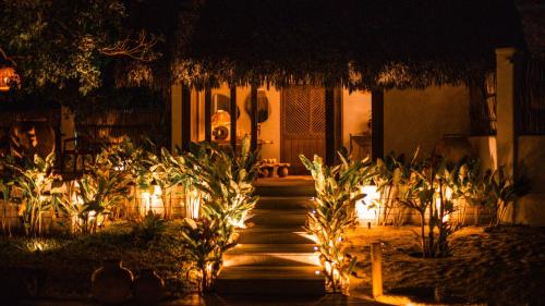 een pad dat 's nachts naar een huis met verlichting leidt bij Anacardier Privé Hotel in Atins