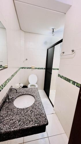 a bathroom with a sink and a toilet at GB Hotéis Foz Rodoviária in Foz do Iguaçu