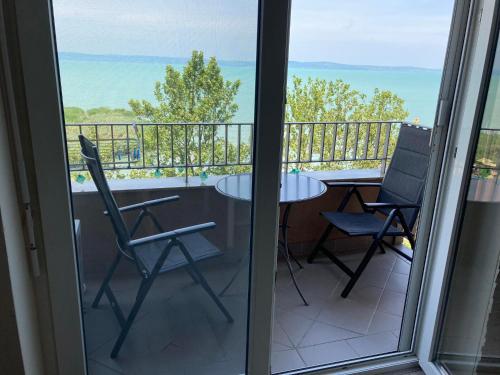 a balcony with a table and chairs and a view at Panoráma Gold Wellness Apartman in Siófok