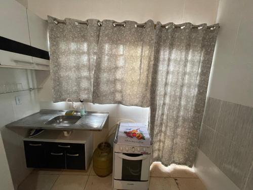uma cozinha com um lavatório e uma cortina de chuveiro em Hospedaria Cmc unidade 12 em Brasília